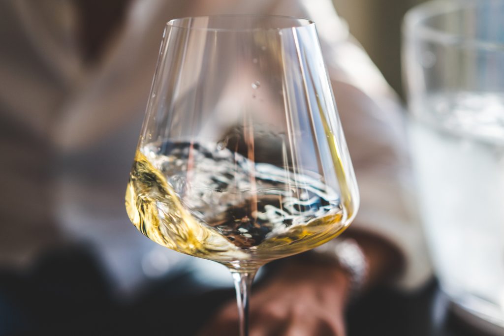 Glas droge witte wijn met citrusvruchten, illustratie van Sauvignon Blanc en Chardonnay soorten