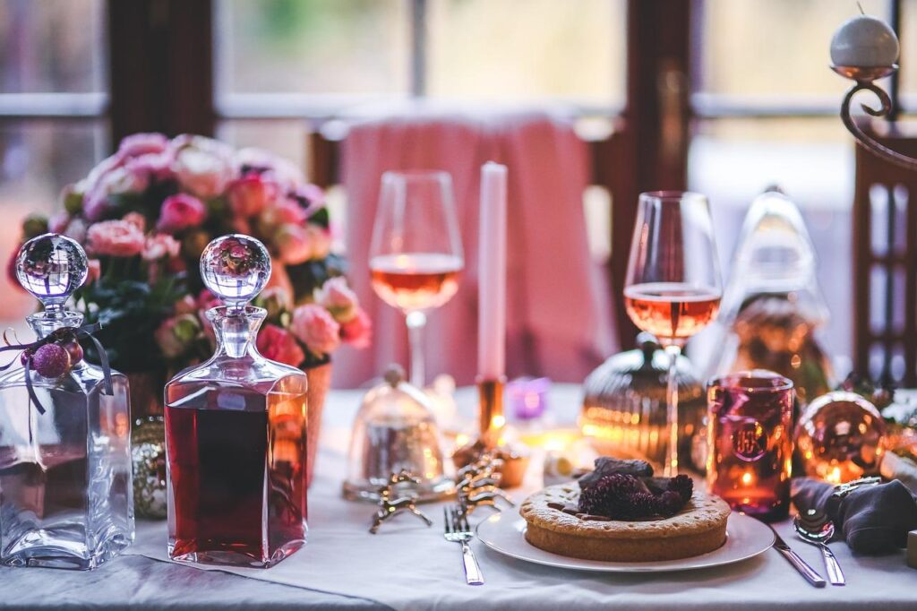 Tafel gedekt met verschillende wijnen en appetizers voor perfecte wijn en eten combinaties tijdens een feestje thuis